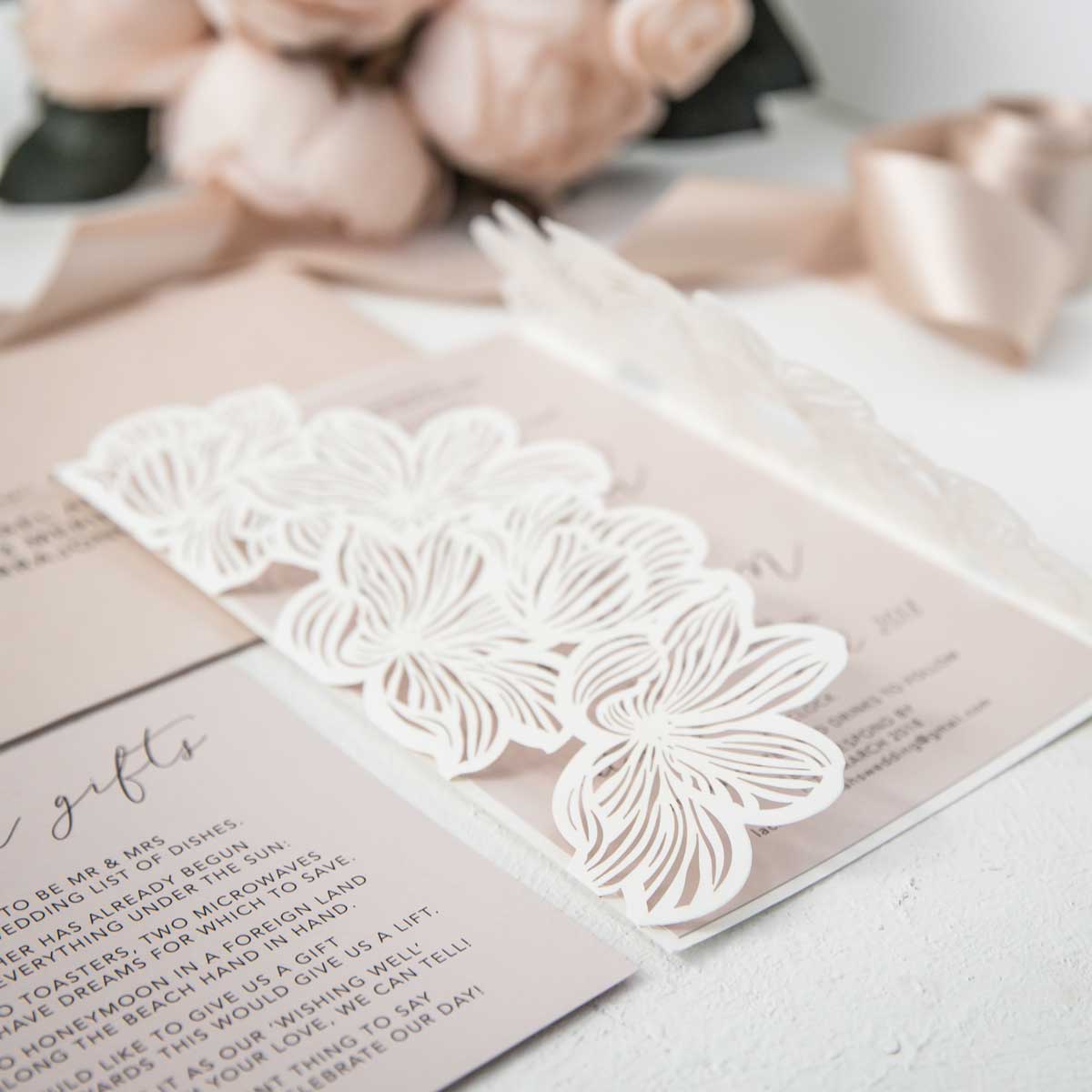 florral laser-cut wedding invitation in white with blush pink invitation cards