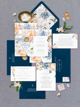 Bridgerton Lake vintage inspired floral wedding invitation featuring blue and peach flowers framing the design with dark blue coloured envelopes, floral liner, detail card, wishing well and rsvp flatlay