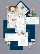 Bridgerton Lake vintage inspired floral wedding invitation featuring blue and peach flowers framing the design with dark blue coloured envelopes, floral liner, detail card, wishing well and rsvp flatlay