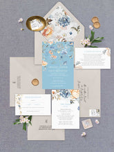 Bridgerton Lake vintage inspired floral wedding invitation featuring blue and peach flowers at the top of the design with neautral coloured envelopes, floral liner, detail card, wishing well and rsvp flatlay
