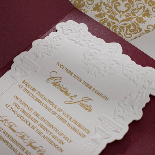 Embossed sculptured wedding invitation featuring roman column design closeup and shown with burgundy velvet pocket