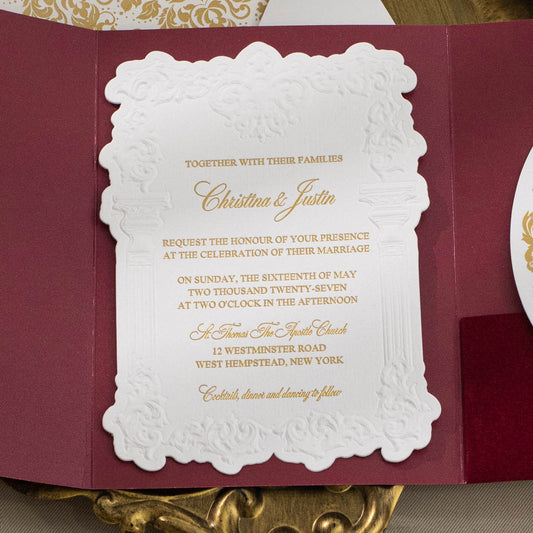 Embossed sculptured wedding invitation featuring roman column design and shown with burgundy velvet pocket
