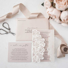 Laser-cut gate-fold wedding invitation featuring flower design on the folds shown in white with blush pink invitation