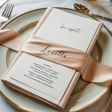 Wedding reception menu with a pink ribbon with guest name on a plate