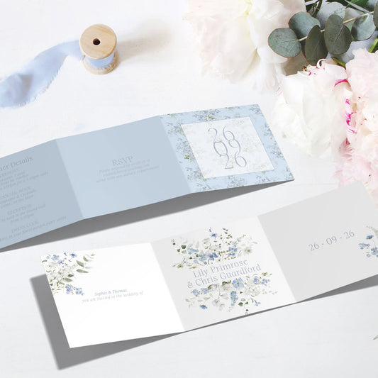 Tri-fold all in one Wedding invitation Primrose Spring card with floral design on a white surface with white and blue flowers