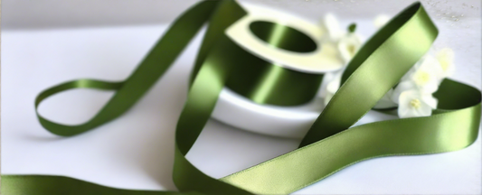 thyme satin ribbon on spool on white table with white flowers