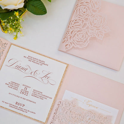 Elegant laser-cut wedding invitation with floral rose design shown with invitation and rose gold glitter backing card and detail card close up

