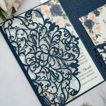 Navy blue laser-cut invitation card with a swirl patterned design