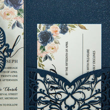 Navy blue laser-cut invitation card with a swirl patterned design featuring blue floral detail card