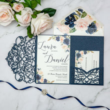 Navy blue laser-cut invitation card with a swirl patterned design featuring blue floral wedding invitation suite with matching floral envelope liner