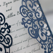 Gate-fold laser-cut wedding invitation featuring a swirl design in navy closeup