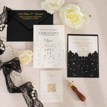 Elegant leaf laser-cut wedding invitations with sculptured embossing, and coordinated stationery, set with black lace design on a light surface with flowers and a sealing stamp.