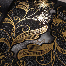 Black Laser-cut gate-fold invitation featuring anemone design with gold foil highlights closeup