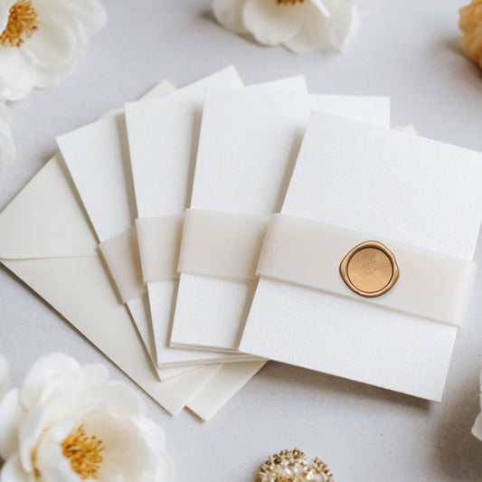 plain vellum belly with antique gold on white card invitation stacked in group