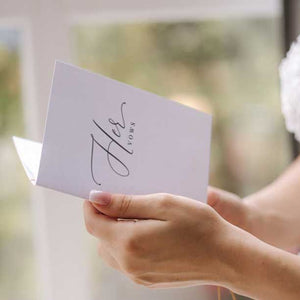 bride holding a vow booklet with modern script font