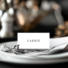 Classic, modern, minalist design Place card with 'Carrie' on a table setting with silverware and a blurred background