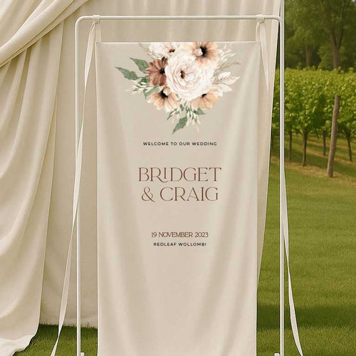 Wedding welcome sign with bohemian floral design and text in an outdoor setting