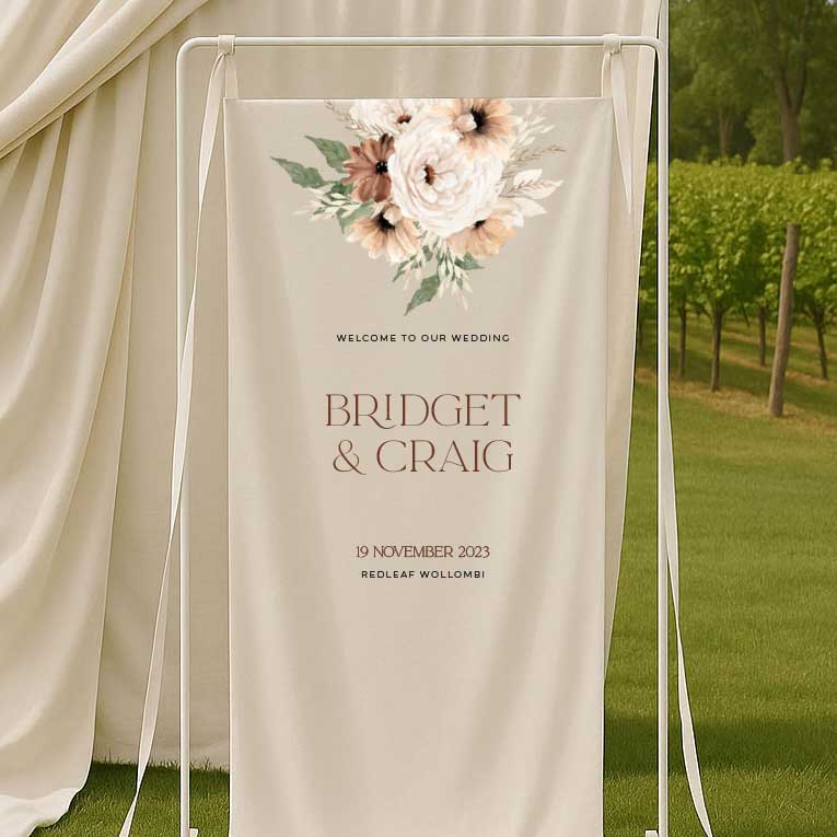 Wedding welcome sign with bohemian floral design and text in an outdoor setting