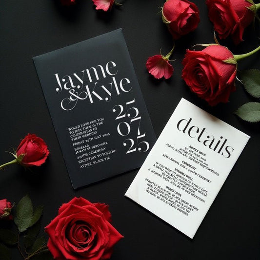 modern chic black and white wedding invitation and details card surrounded by red roses

