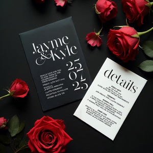 modern chic black and white wedding invitation and details card surrounded by red roses
