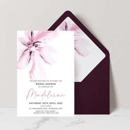 bridal shower invitation featuring a pink magnolia flower in a modern watercolour design set with a burgundy envelope and matching envelope liner