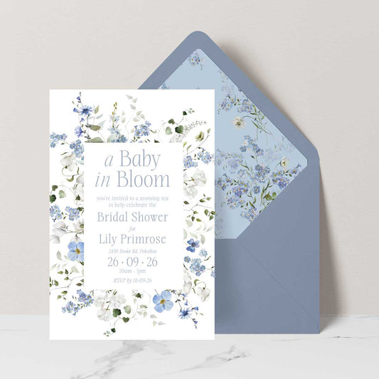 Baby shower invitation with Primrose Spring floral design featuring 'a baby in bloom' dusty blue envelope with floral liner