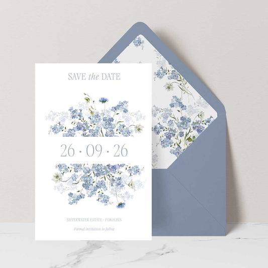 Primrose Spring Save the Date card, hand-painted botanicals in powder blue, soft white and fresh green gently frame the invitation, featuring a dusty blue envelope with matching floral liner