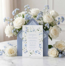 Primrose Spring Wedding Invitation, hand-painted botanicals in powder blue, soft white and fresh green gently frame the invitation, featuring a dusty blue envelope with matching floral liner surrounded by white roses and blue flowers