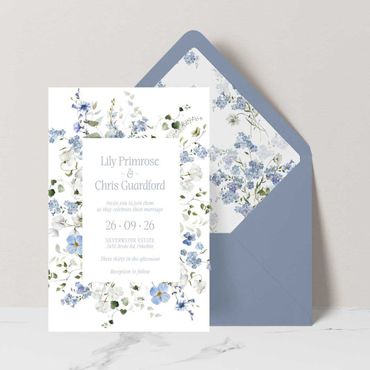 Primrose Spring Wedding Invitation, hand-painted botanicals in powder blue, soft white and fresh green gently frame the invitation, featuring a dusty blue envelope with matching floral liner