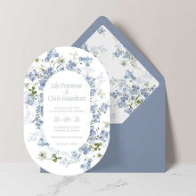 Primrose Spring Wedding Invitation suite in an oval shape, hand-painted botanicals in powder blue, soft white and fresh green gently frame the invitation, featuring a dusty blue envelope with matching floral liner