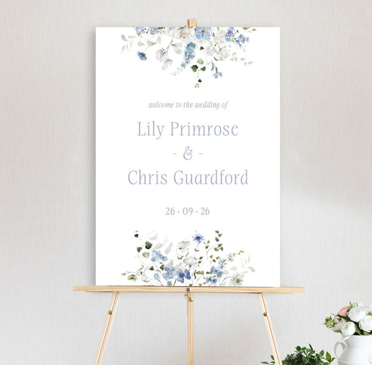 Wedding sign with white and blue floral design primrose spring collection and text on a stand against a light background