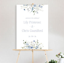 Wedding sign with white and blue floral design primrose spring collection and text on a stand against a light background