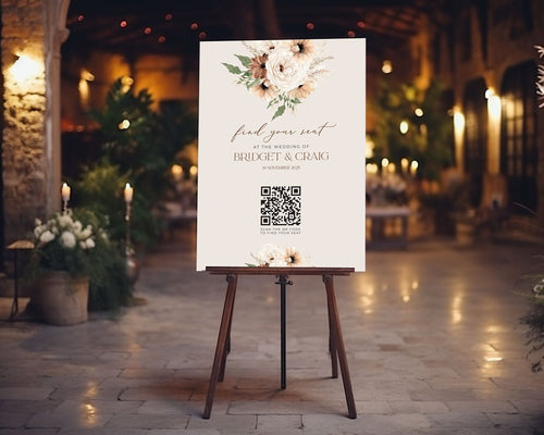 qr code table seating sign sitting on easel at wedding reception featuring boho peonie floral bouquet
