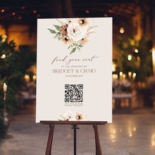 qr code table seating sign sitting on easel at wedding reception featuring boho peonie floral bouquet