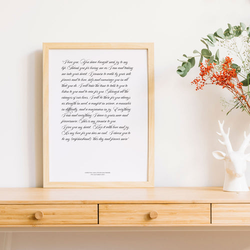 1st year wedding anniversary vow prints in a script font in frame on timber table 
