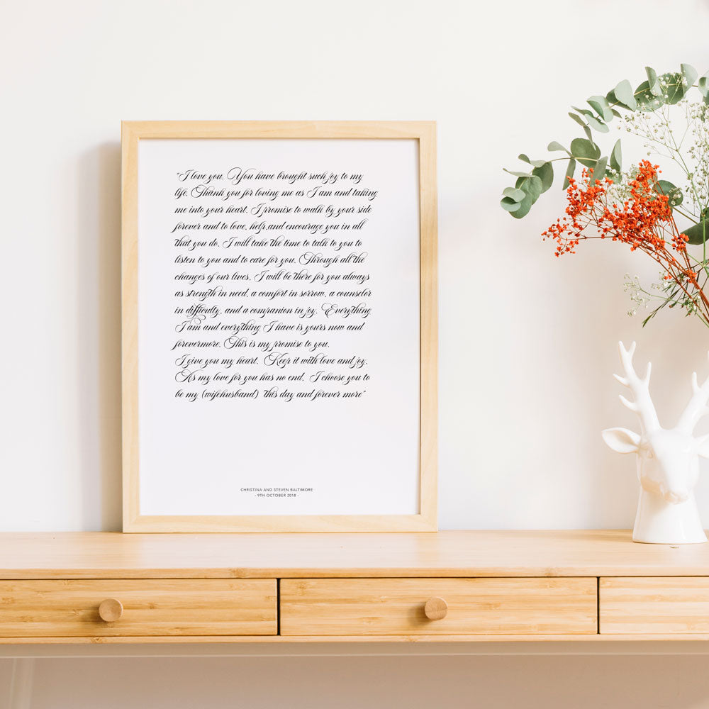 1st year wedding anniversary vow prints in a script font in frame on timber table 
