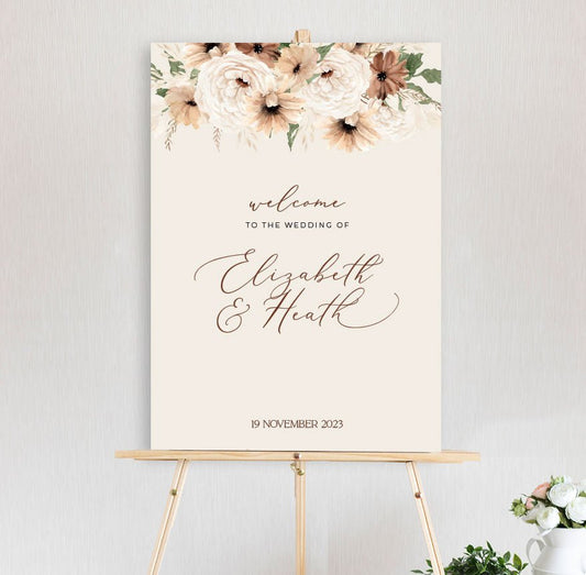 a bohemian floral welcome sign featuring peonies and daisy in autumn brown and neutral tones, on timber easel
