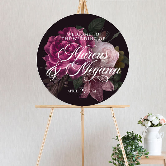 circle welcome sign featuring moody burgundy and pink peonie roses sitting on timber easel