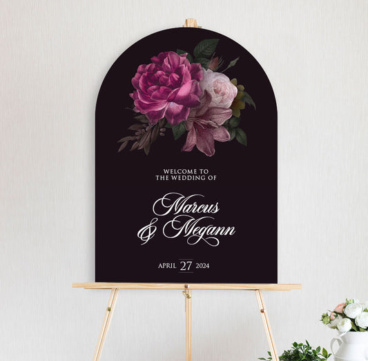 arch shape welcome sign featuring moody burgundy and pink peonie roses sitting on timber easel