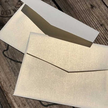 curious metallic white gold envelopes closeup