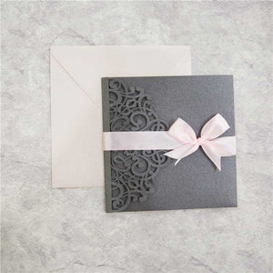 grey laser-cut invitation with pink ribbon open