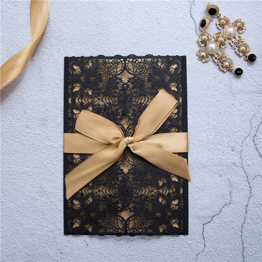black and gold laser-cut invitation with ribbon closed