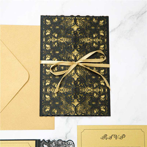 black and gold laser-cut invitation with ribbon closed