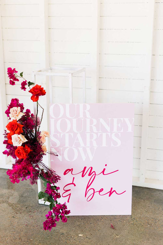 fun our journey starts now colourful red, pink and white welcome sign with red and pink roses from neon dream collaboration