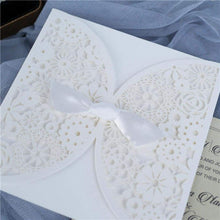 Laser-cut Wedding Invitation featuring a doily floral design oined in the middle, embellished with a white bow closeup