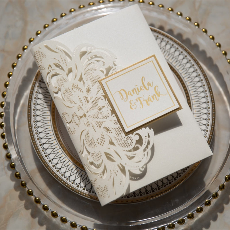 laser-cut wedding invitation in ivory with gold name tag