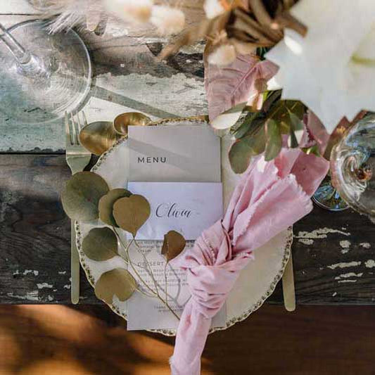 napkin wrap with pink napkin in a rustic wedding setting