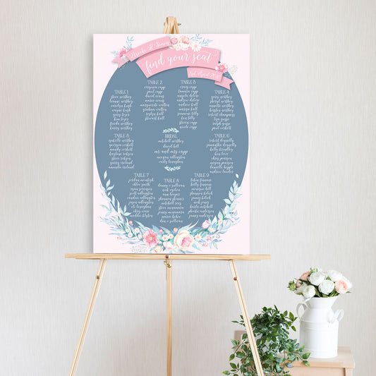 table seating chart featuring watercolour pink peonie flowers in blue oval shape with scroll flags and sitting on timber easel