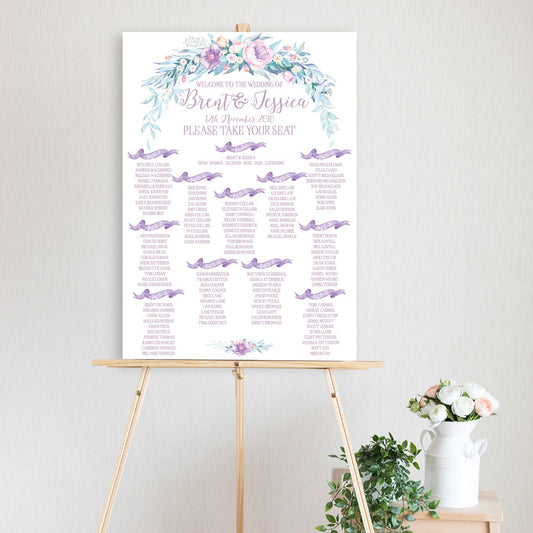 table seating chart featuring watercolour peonie flowers in lavender with scroll flags and sitting on timber easel