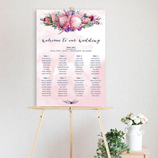 watercolour king protea design with pink watercolour background table seating chart sitting on a timber easel